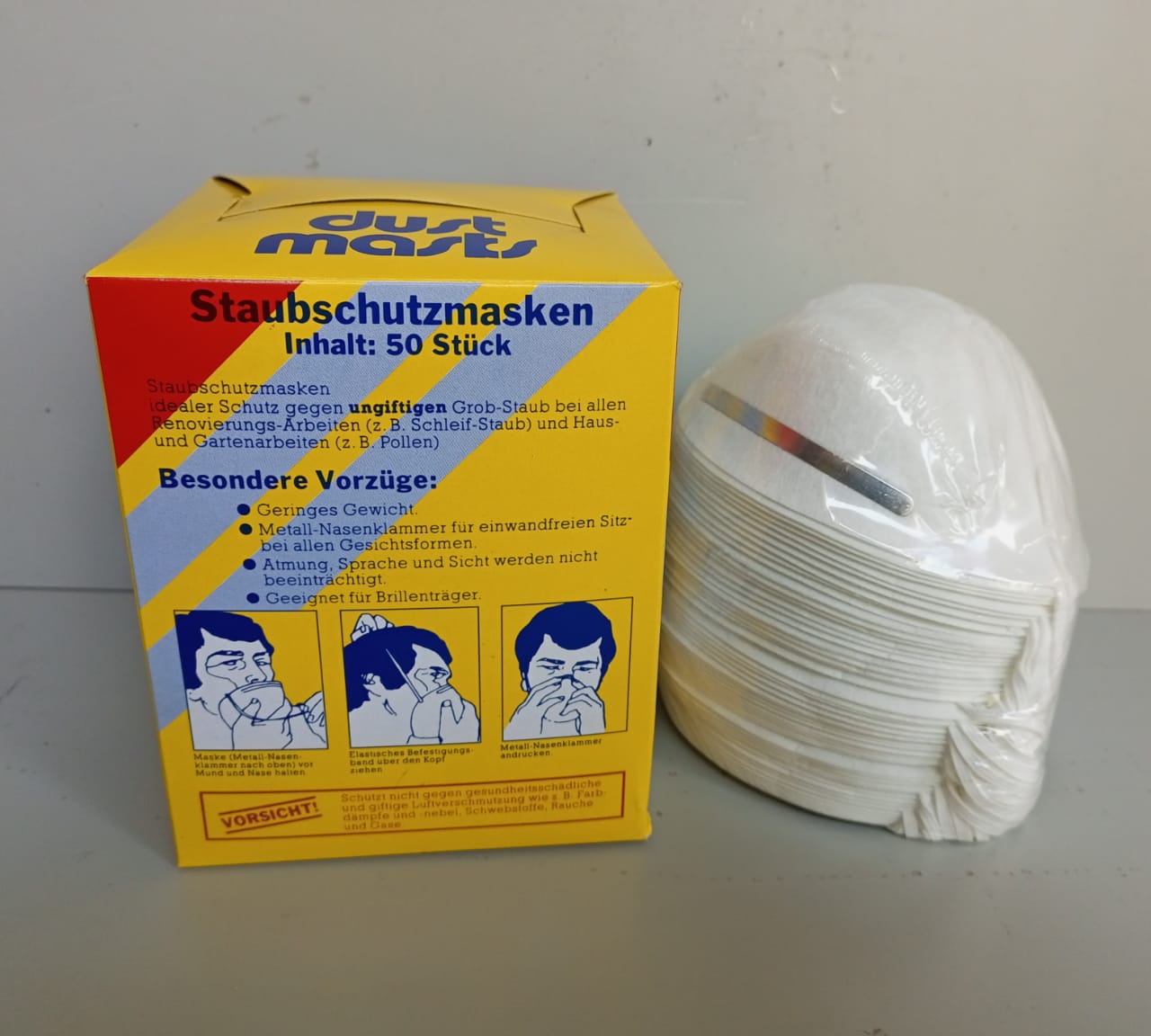 Yellow packet disposable dust mask designed for protection against dust and airborne particles in workplace environments